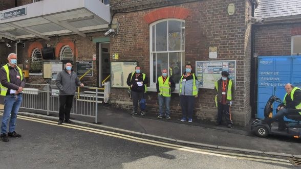 People in high visibility vest standing outside Arundel railway station