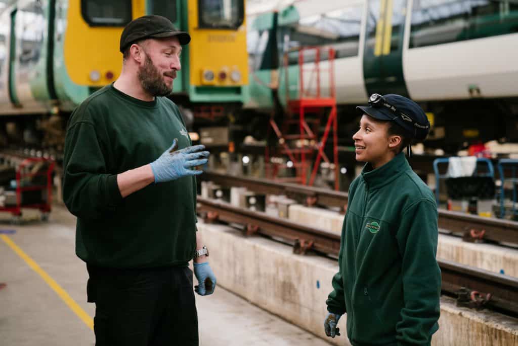 Male and female apprentices talking at Southern's railway depot