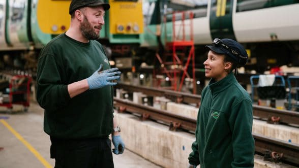 Male and female apprentices talking at Southern's railway depot
