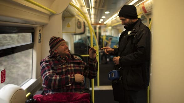GTR staff talking to customer in wheelchair on a train